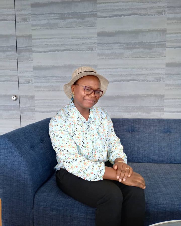 Estelle Metsago sitting on a blue sofa