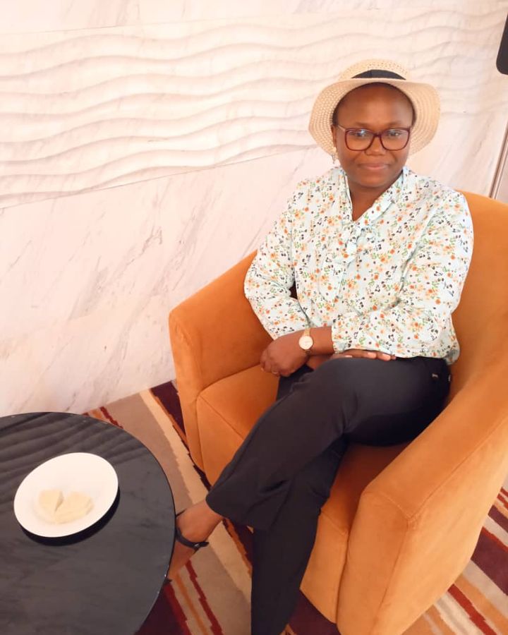 Estelle Metsago sitting in an orange armchair