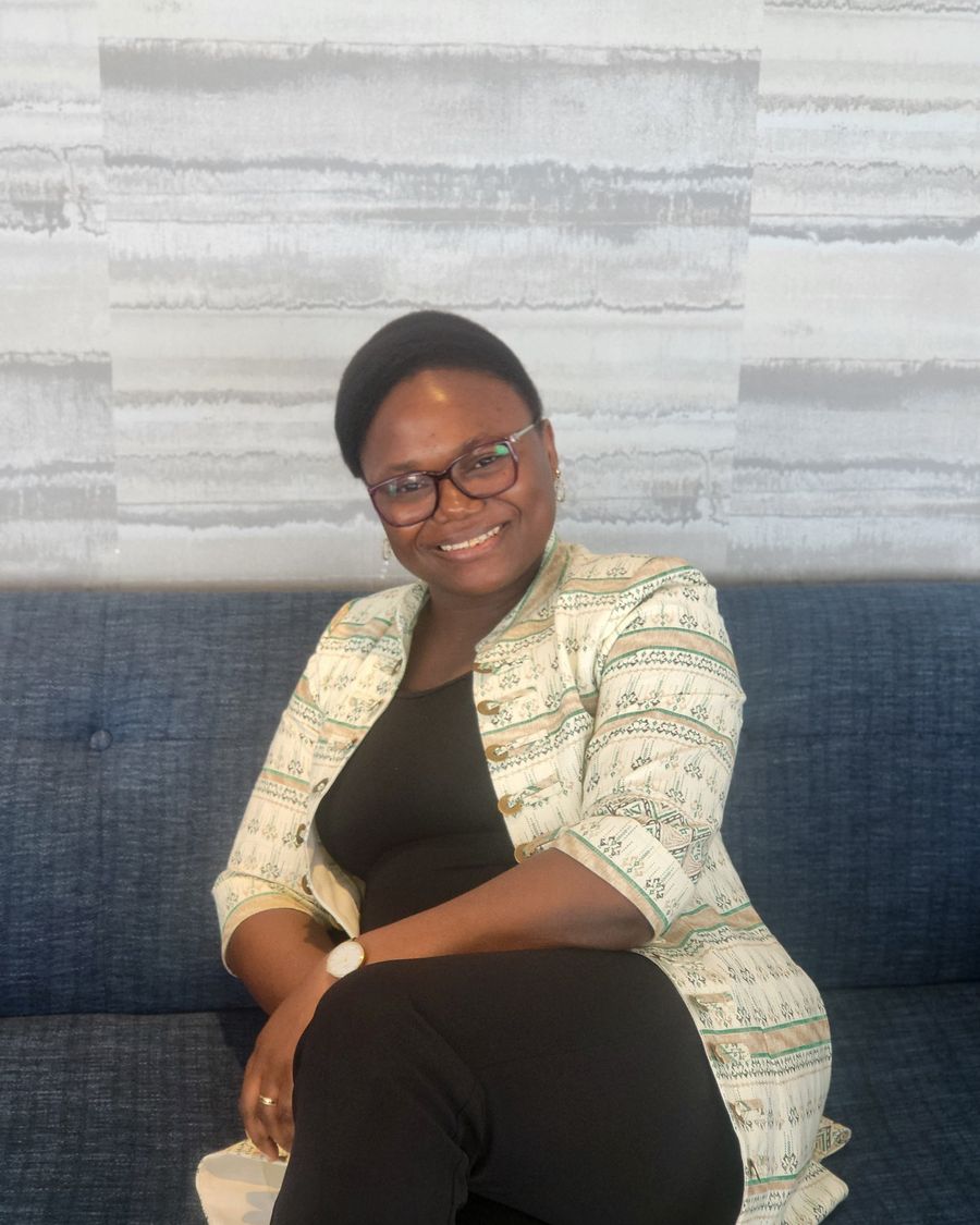Estelle Metsago, souriante, assise sur un canapé